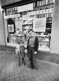 Children in front of a delicatessen with advertising for the anniversary of the Republic