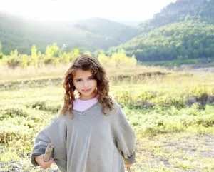 Children girl hiking in mountain with father sweater