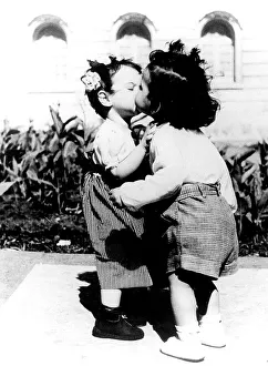 Two children kiss each other, ca