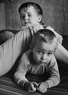 Children playing at their mother's leg