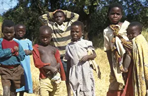 Children posing for the camera on the side of the road