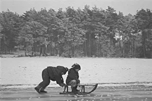 Children ride sledges on ice rink