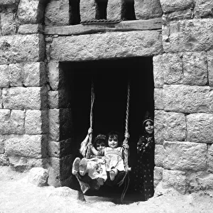 Children rocking in a house entrance, Amran, Yemen, Asia