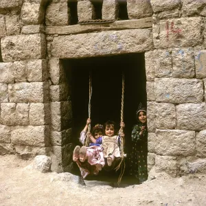Children rocking in a house entrance, Amran, Yemen, Asia