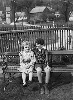 Two children sitting on a bench