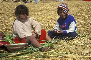 Children sitting on a floating Uro island in Lake Titcaca