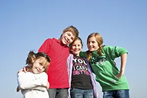 Four children standing arm in arm