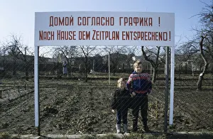 Children standing beneath a sign that reads going home