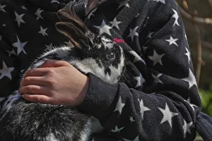 Child's hand holding black and white hare on black and white jacket