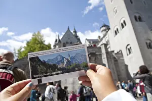Child's hand holding ticket to visit Neuschwanstein castle