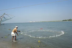 Chinese fishing net and fisherman throwing net in sea
