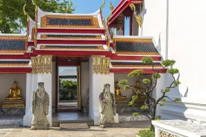 Chinese guardian figures beside a gate at the cloister of the Wat Pho temple in Bangkok
