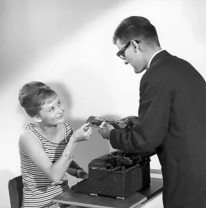 Chocolate in the 1960s. A man offers a woman a piece of a chocolate bar