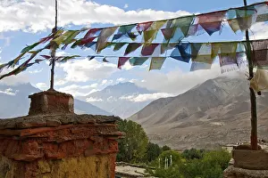 The Chorten and prayer flags on a background of mountains and clouds