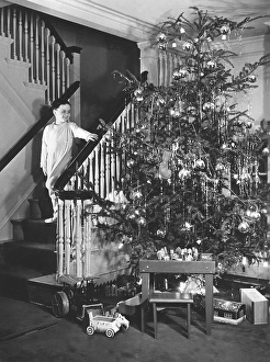 Christmas in the 1940s. A boy is coming down the stairs on christmas day