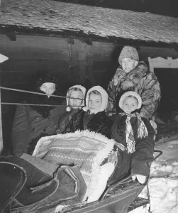 Christmas 1940s. A family is ready to go to the early service in church on christmas morning. A father and his three girls are well dressed for the freezing cold weather. Sweden 1944