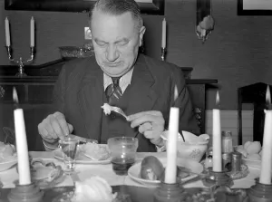 At christmas in the 1940s. A man is having christmas dinner and by the look of his face the dish is not in his taste