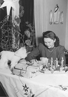 Christmas in the 1940s. A woman is wrapping christmas gifts