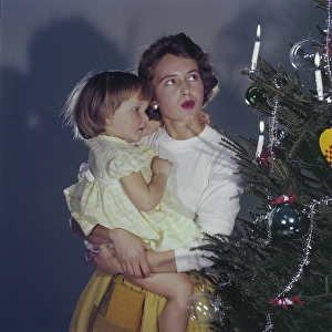 Christmas in the 1950s. A mother and her daughter is standing by the christmas tree