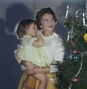 Christmas in the 1950s. A mother and her daughter is standing by the christmas tree