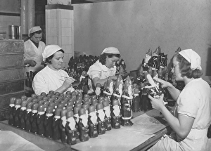 Christmas chokolate. Three young employees in the factory of the swedish chocolate maker company Cloetta. They are busy finishing the chocolate santa clauses that needs to be delivered to the stores