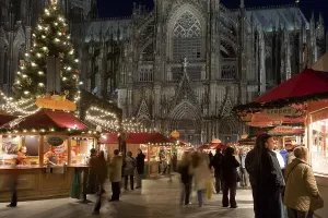 Christmas market stalls and people in front of the Cologne Cathedral
