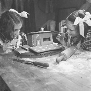 Christmas time in the 1940s. Two sisters are building a ginger bread house