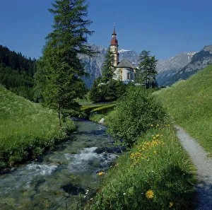 Church, stream and spring meadow in Obernberg am Brenner