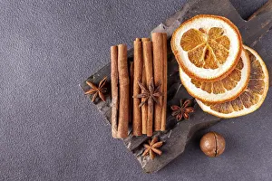Cinnamon sticks, star anise, dried orange on a wooden board
