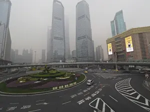 Framed Print : City scene with roundabout and skyscrapers in fog under grey sky