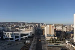 City street flanked by buildings stretching into the distance under a clear sky