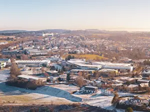 Cityscape in winter with various architectures and hills in the background