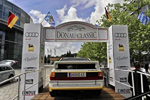 Classic car at the Donau Classic in front of a starting point with flags