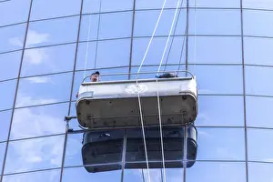 Two cleaners washing the windows of modern skyscraper in New York