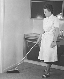 Cleaning day in the 1950s. A young woman dressed in a practical cleaning outfit