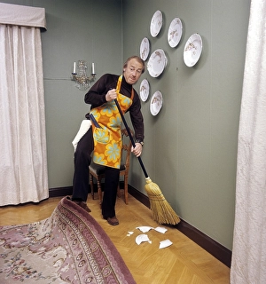 Cleaning day in the 1970s. An interior of a man cleaning the floor