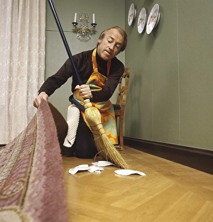 Cleaning day in the 1970s. An interior of a man cleaning the floor