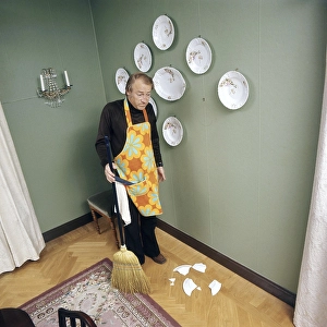 Cleaning day in the 1970s. An interior of a man cleaning the floor
