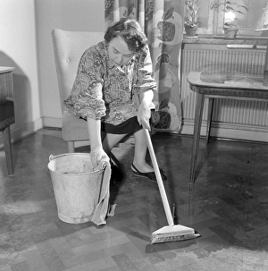 Cleaning the floor back then. A woman looks very tired and worn out when sitting on a chair