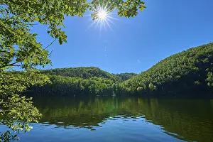 Clear lake landscape with bright sun in the blue sky