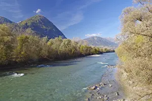 Clear river with gravel bank between autumn trees