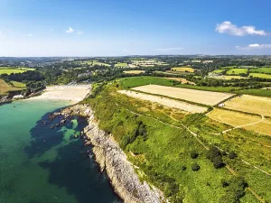 Cliffs over Maenporth Beach and Stack Point from a drone