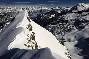 Climber on mountain top with mountain panorama