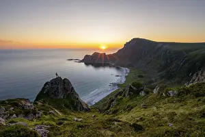 Climber on rocks in front of picturesque landscape