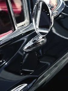Close up of an old sideview mirror of a vintage car