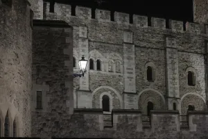 Close-up of a castle's stone wall with intricate architectural details at night at The Tower of London