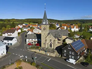 Close-up of a church in a village surrounded by roads and modern houses
