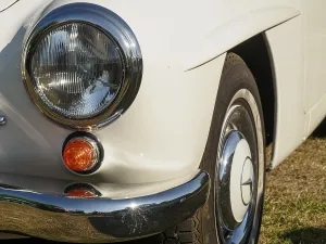 Close-up of a classic car with headlights and shiny chrome details