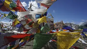 Close-up, colorful prayer flags waving in the wind in front of a temple at Khardung-La Pass in the mountainous