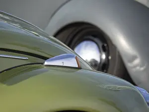 Close-up of a green vintage car with shiny chrome and headlights